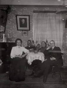 Neljä aikuista istuu pöydän ympärillä.