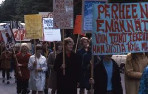 Kulkueessa nuorisoa. Kyltit käsissä.