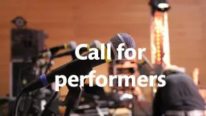 Lähikuva mikrofonista, jonka päällä teksti Call for performers.