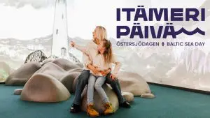 Itämeripäivän logo kuvassa, jossa äiti ja tytär hämmästelevät merellisessä näyttelytilassa.