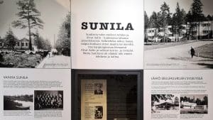 Yksityiskohta näyttelytilan seinästä teksti- ja kuvaplansseineen.