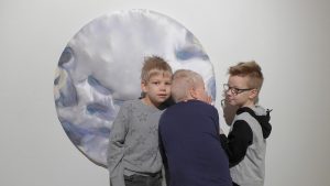 Kolme nuorta poikaa koskelteltavaa taideteosta tunnustelemassa